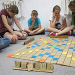 uczniowie grają na dywanie w grę planszową.jpg