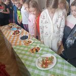 dzieci stoją przy stołach z przekąskami.jpg