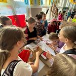 Grupa uczniów przy stoisku prezentującym Chiny
