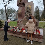Uczennice stawiają znicze przy Pomniku Katyńskim.jpg