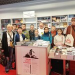 Grupa uczniów wraz z nauczycielką pozuje do zdjęcia na Targach Książki