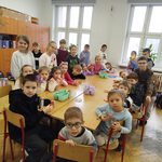 Uczniowie wraz z przedszkolakami siedzą przy stoliku
