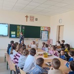 Dzieci siedzą w ławkach