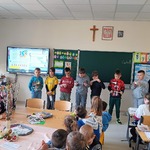 Dzieci stoją przy tablicy podczas zajęć