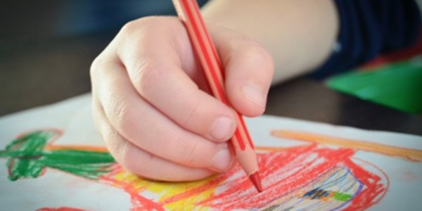 ręka dziecka, która maluje kredkami