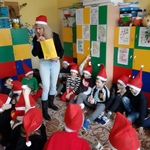 Dzieci siedzą w kole na dywanie i omawiają wraz z nauczycielem list od Mikołaja.