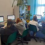 uczniowie siedzą przed komputerem 
