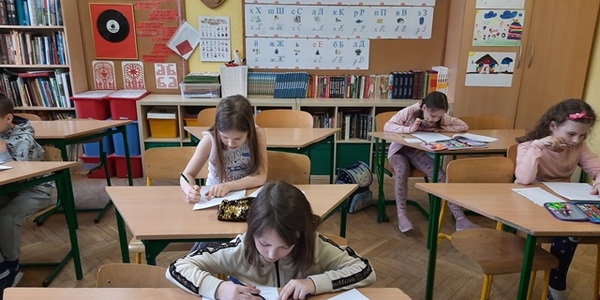 Skupione dzieci rozwiązują test matematyczny