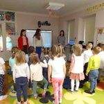 Grupa przedszkolaków, dwie dziewczyny oraz biblitekarka  stoją