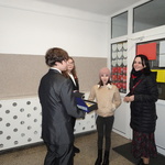 chłopiec czestuje dziewczynkę i jej mamę cukierkami przy wejściu do szkoły.JPG
