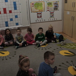 dzieci z przedszkola siedzą na dywanie