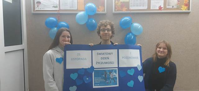 chłopiec i dwie dziewczynki ubrani na niebiesko trzymaja niebieski plakat z napisem  Światowy Dzień Życzliwości i pozdrowień oraz uchwalenie Konwencji Praw dziecka UNICEF.jpg