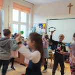 uczniowie tańczą w kółeczku w sali lekcyjnej.jpg