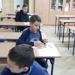 dzieci siedza w ławkach i robia kartki swiateczne dla ukraińskich żołnierzy.jpg