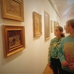 dwie uczennice oglądają obrazy olejne Bencjona Rabinowicza.jpg
