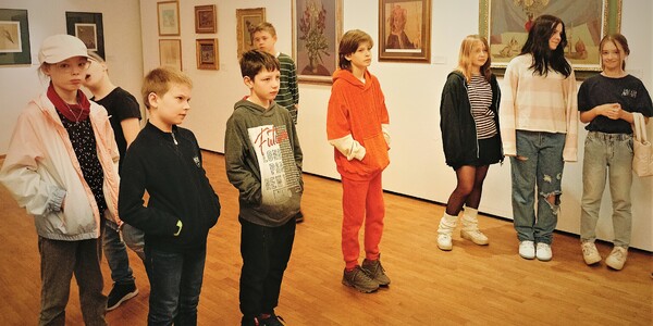 dziewięcioro uczniów stoi w sali wystawowej.jpg