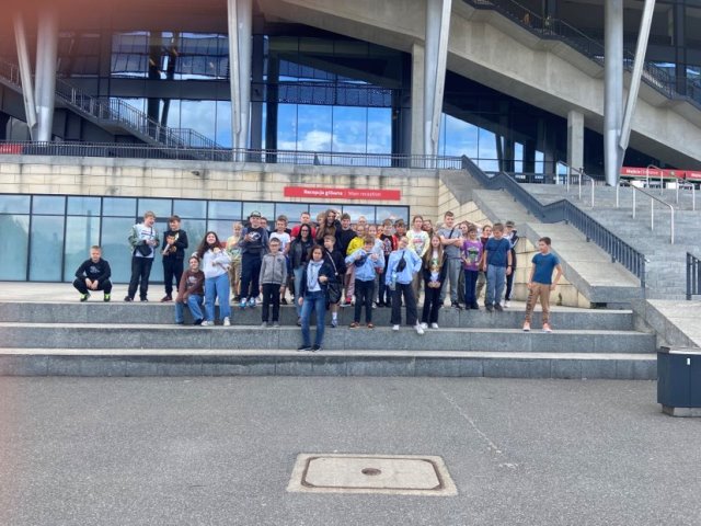 uczniowie stoją w grupie na schodach przed Stadionem Narodowym.jpg