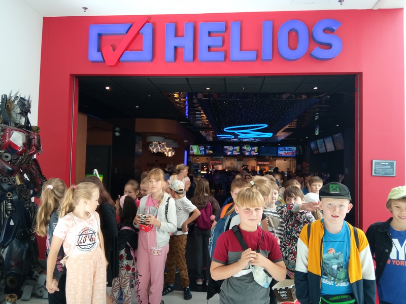 grupa dzieci stoi przed wejściem do kina.jpg